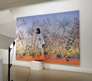A woman standing in front of an artwork